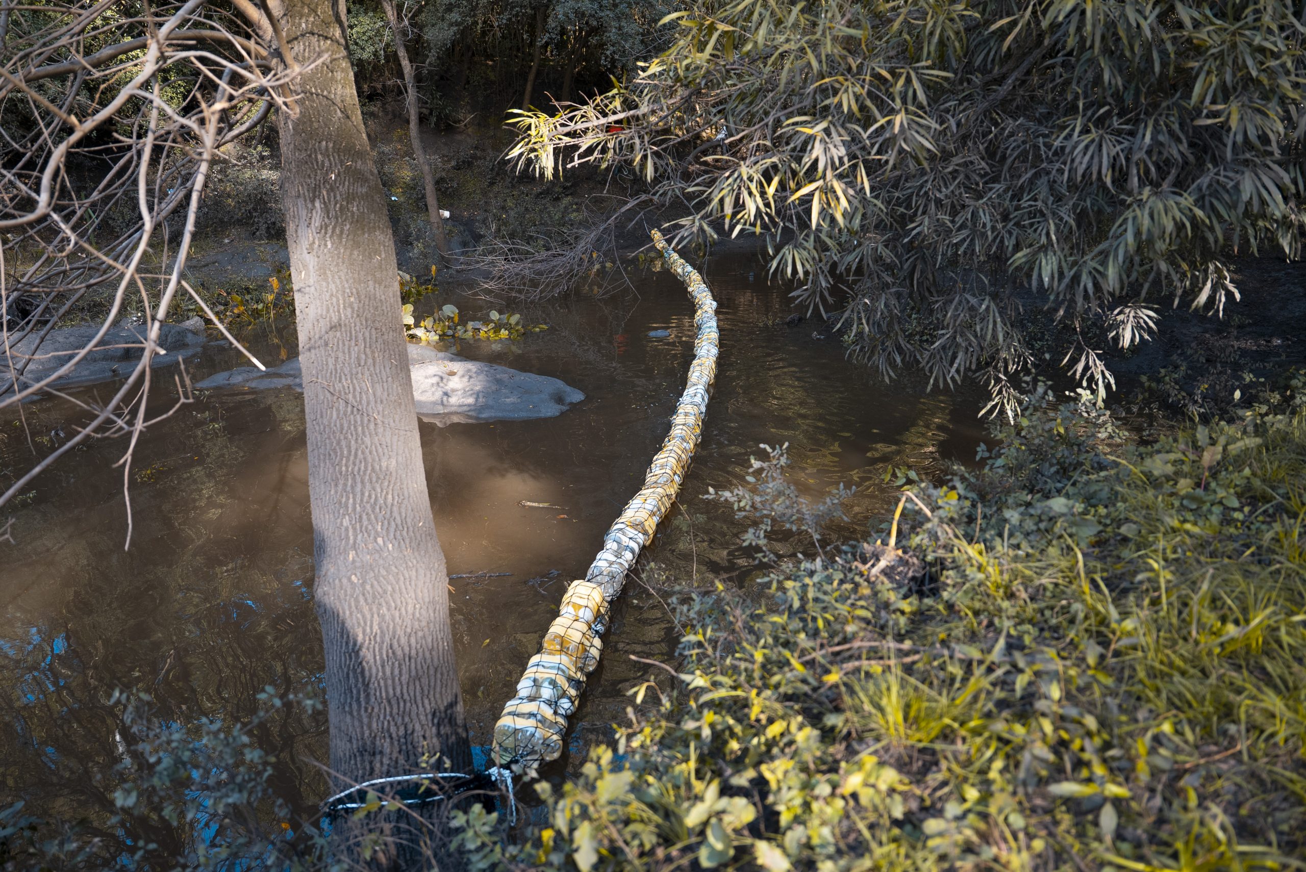 Las biobardas son barreras flotantes que se colocan en este caso sobre el Río Mallada en San José, para frenar y recolectar residuos sólidos —principalmente plásticos— antes de que lleguen a cuerpos de agua más grandes como lagos, embalses o el mar. Están construidas con materiales simples y accesibles (como envases de plásticos, y funcionan de forma pasiva: aprovechan la corriente del agua para atrapar los residuos flotantes sin afectar el cauce natural. Este proceso contó con la colaboración de estudiantes de la Escuela N°68 y N°3 junto a la Intendencia de San José, el equipo del IMFIA y de AUA.